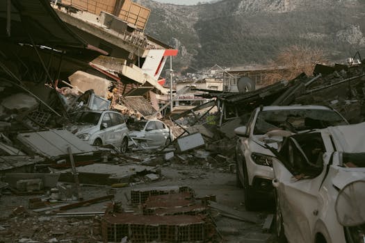 Severe earthquake damage in Antakya, Türkiye, with collapsed buildings and cars.